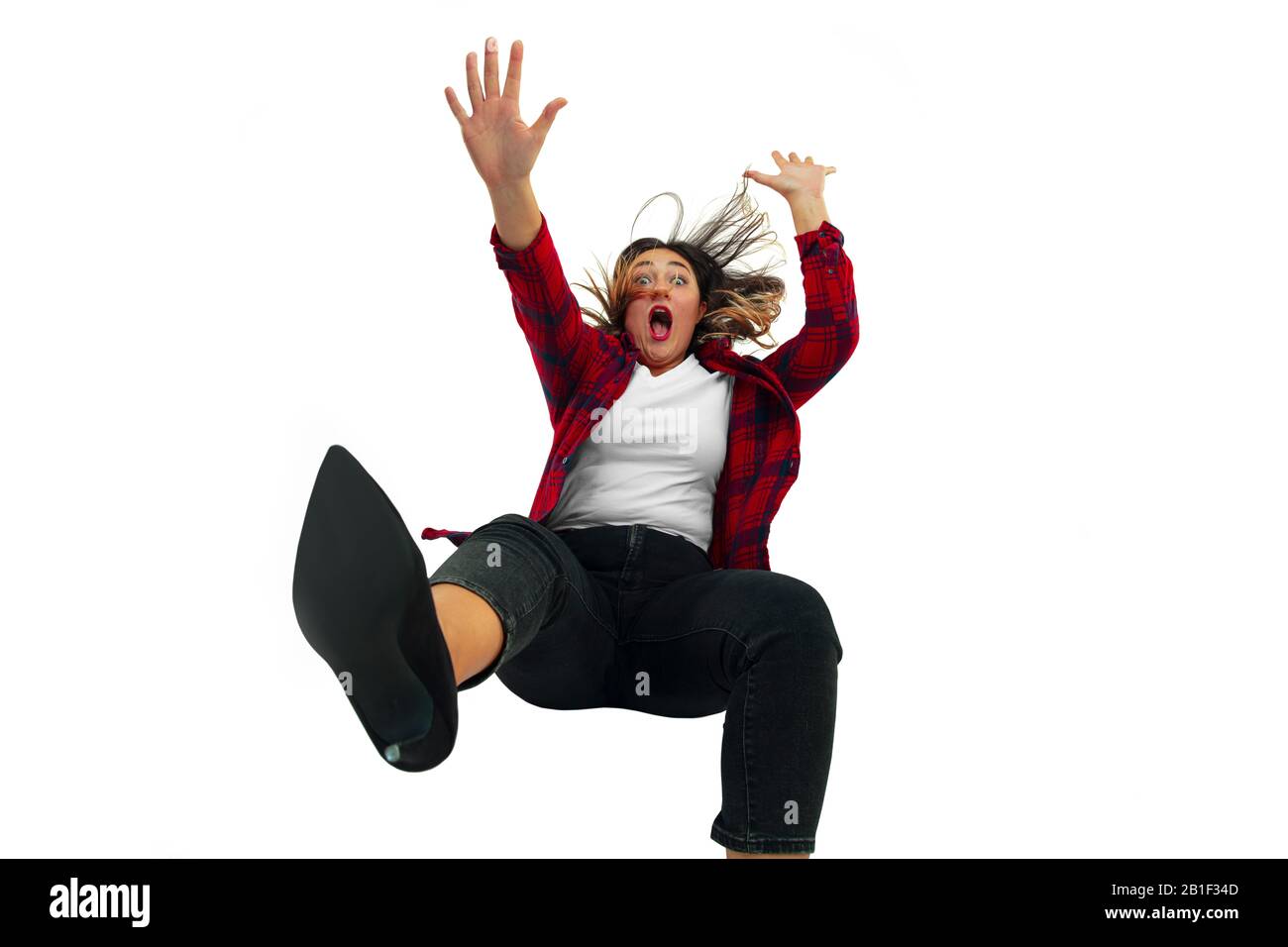 A second before falling. Caucasian young girl falling down in moment with bright emotions and facial expression. Female model in casual clothes. Shocked, scared, screaming. Copyspace for ad. Stock Photo