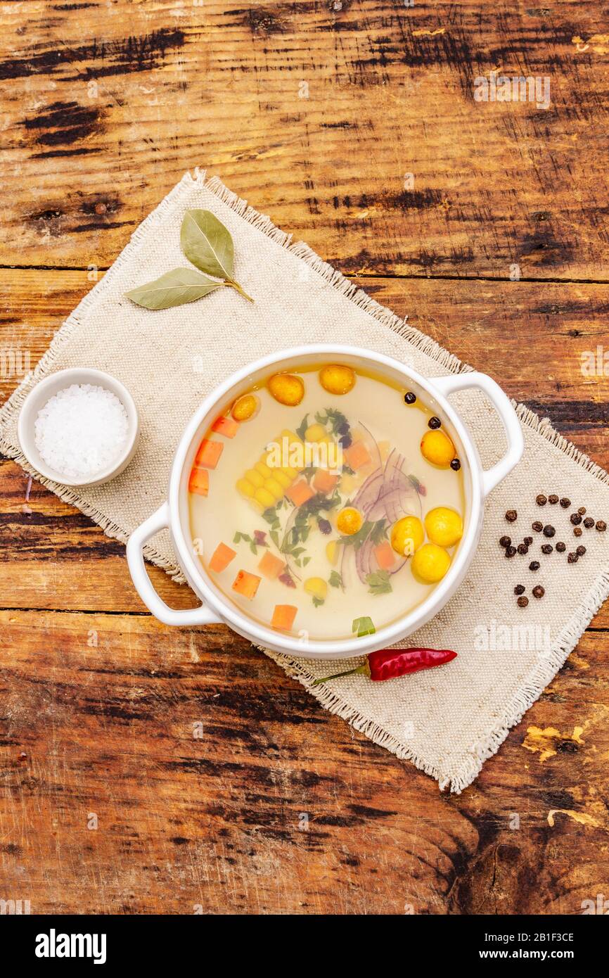 Transparent duck broth with dumplings and vegetables. Traditional