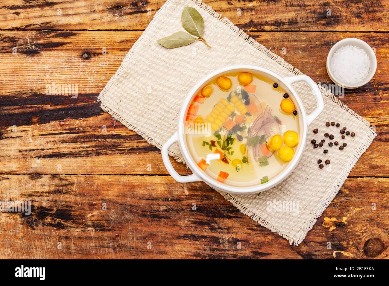 Transparent duck broth with dumplings and vegetables. Traditional