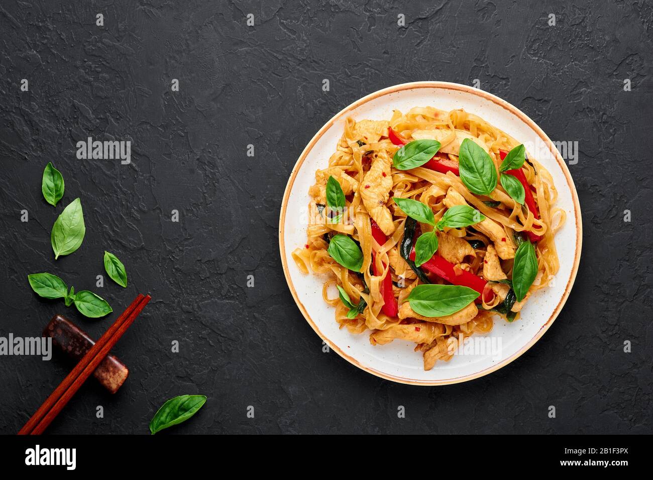 Thai Drunken Noodles or Pad Kee Mao in white plate at black slate