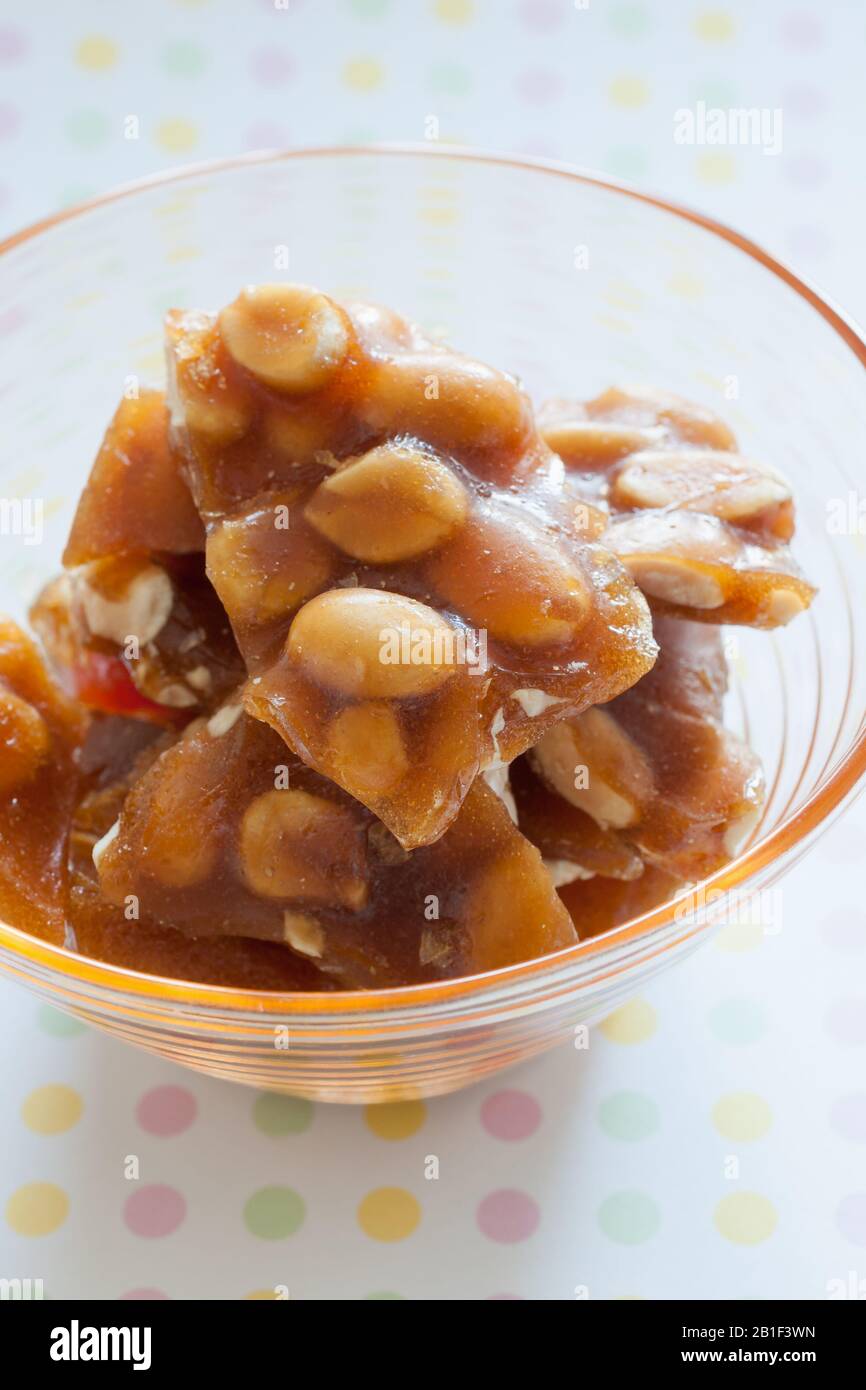 Peanut brittle pieces of hard sugar candy with peanuts Stock Photo