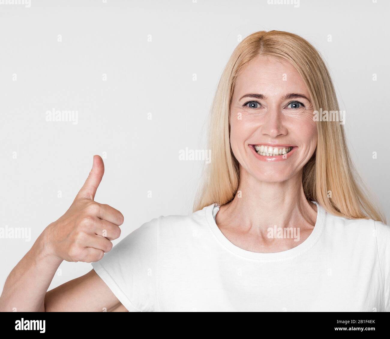 Portrait of mature woman showing thumb up Stock Photo