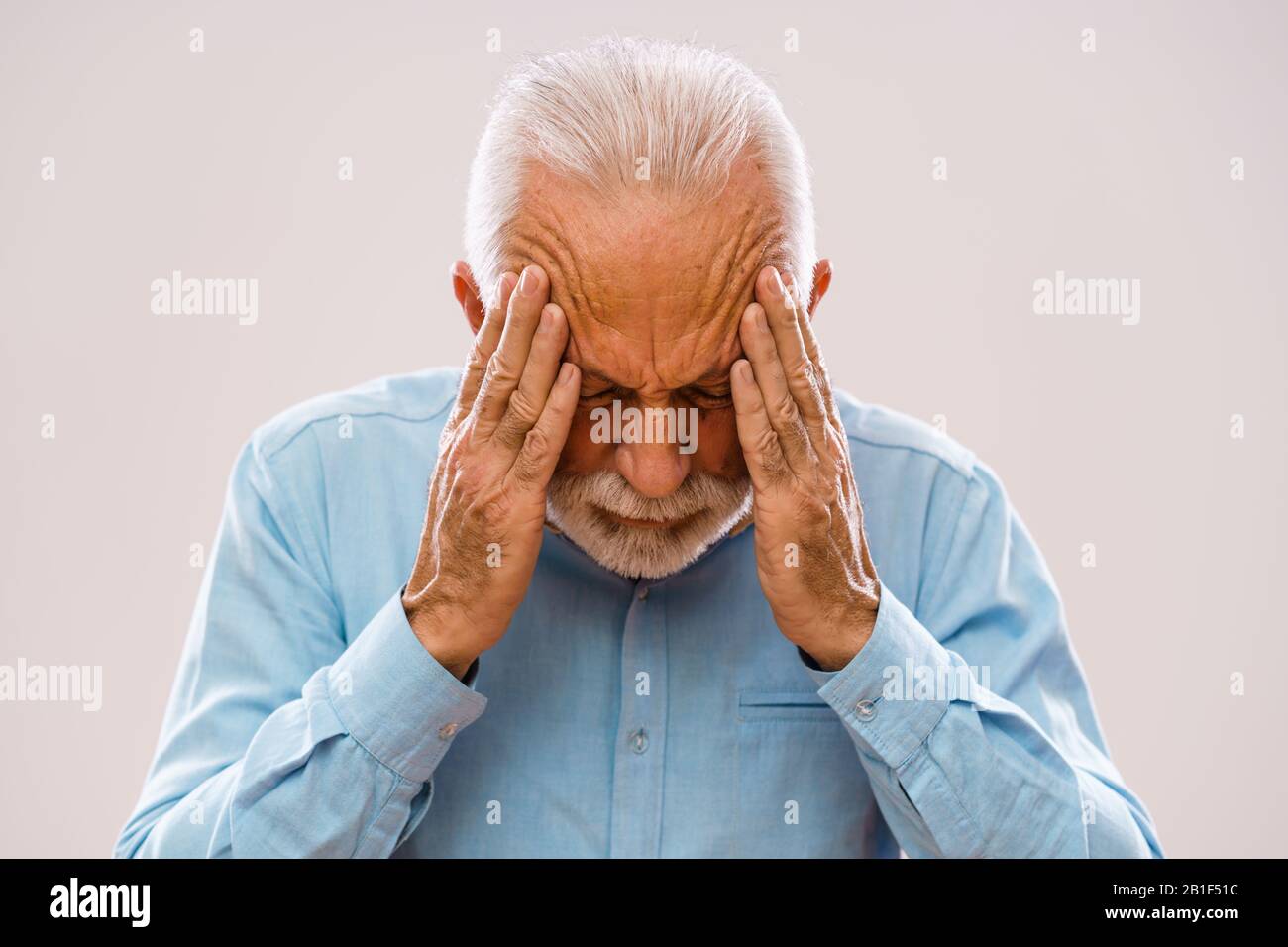 Portrait of senior man who is having headache. Stock Photo