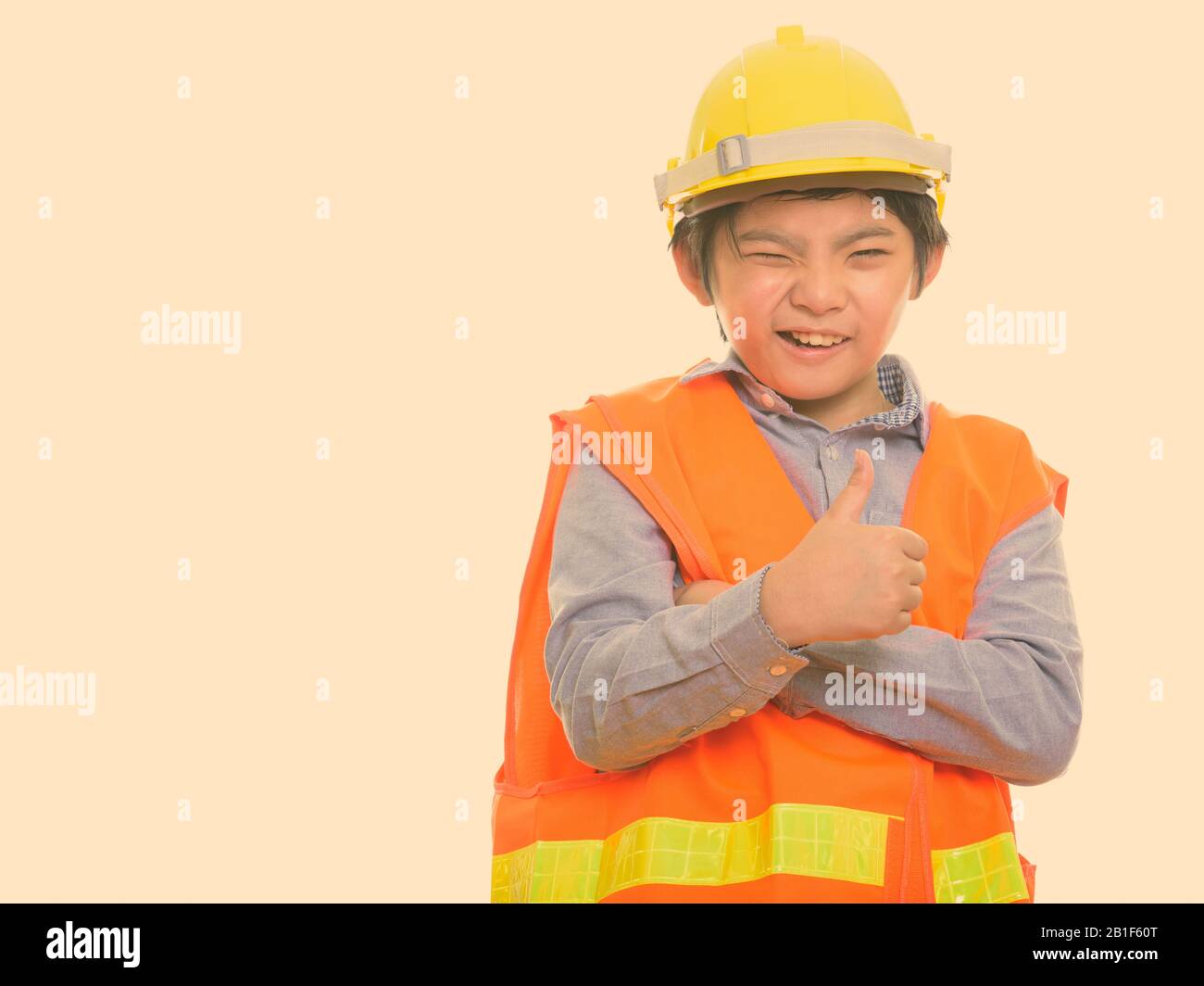 Happy Japanese boy construction worker smiling and winking while giving thumb up Stock Photo
