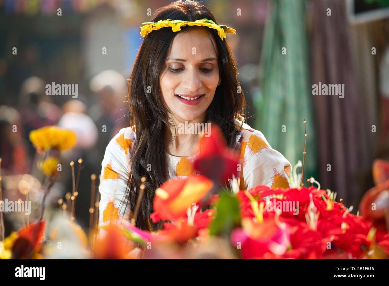 Women trying on floral tiara at street market Stock Photo