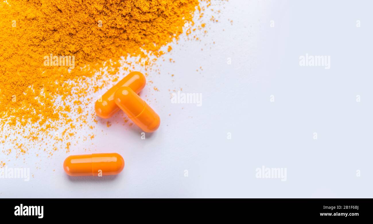 Supplement pills of curcumin or turmeric with a heap of the spice Stock