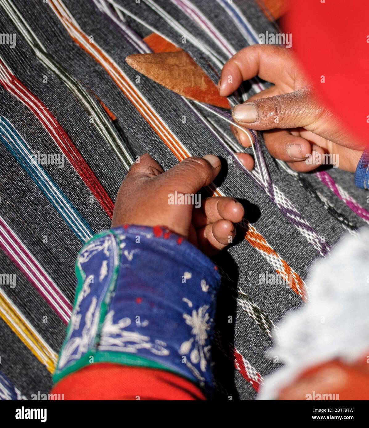 Traditional weaving with alpaca and llama wool by local woman from Ccaccaccollo in the Sacred Valley, Peru. Stock Photo