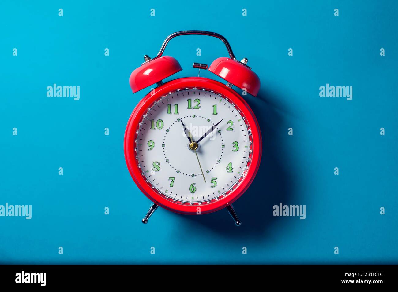 Red alarm clock on the color background. Stock Photo
