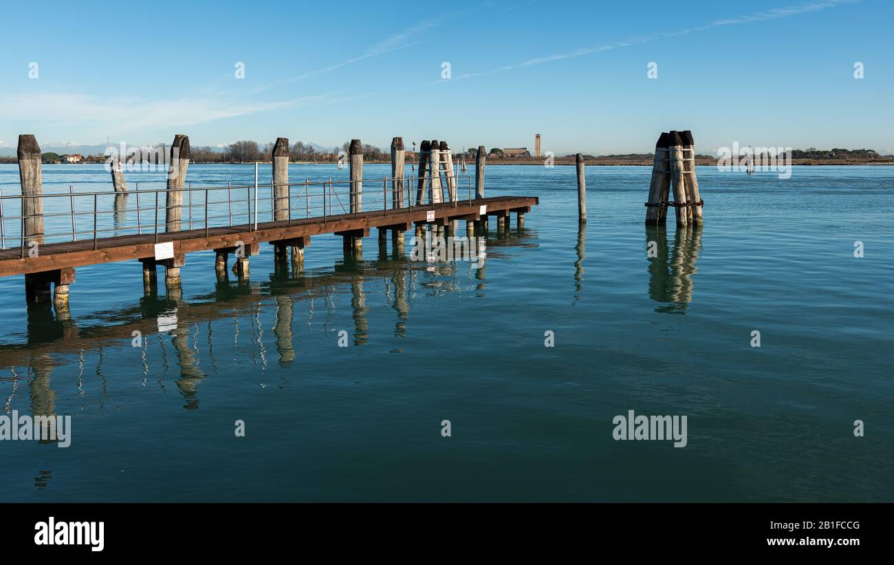 Jetty and wooden bollard in the lagoon of Venice (Italy) on a sunny day in winter Stock Photo