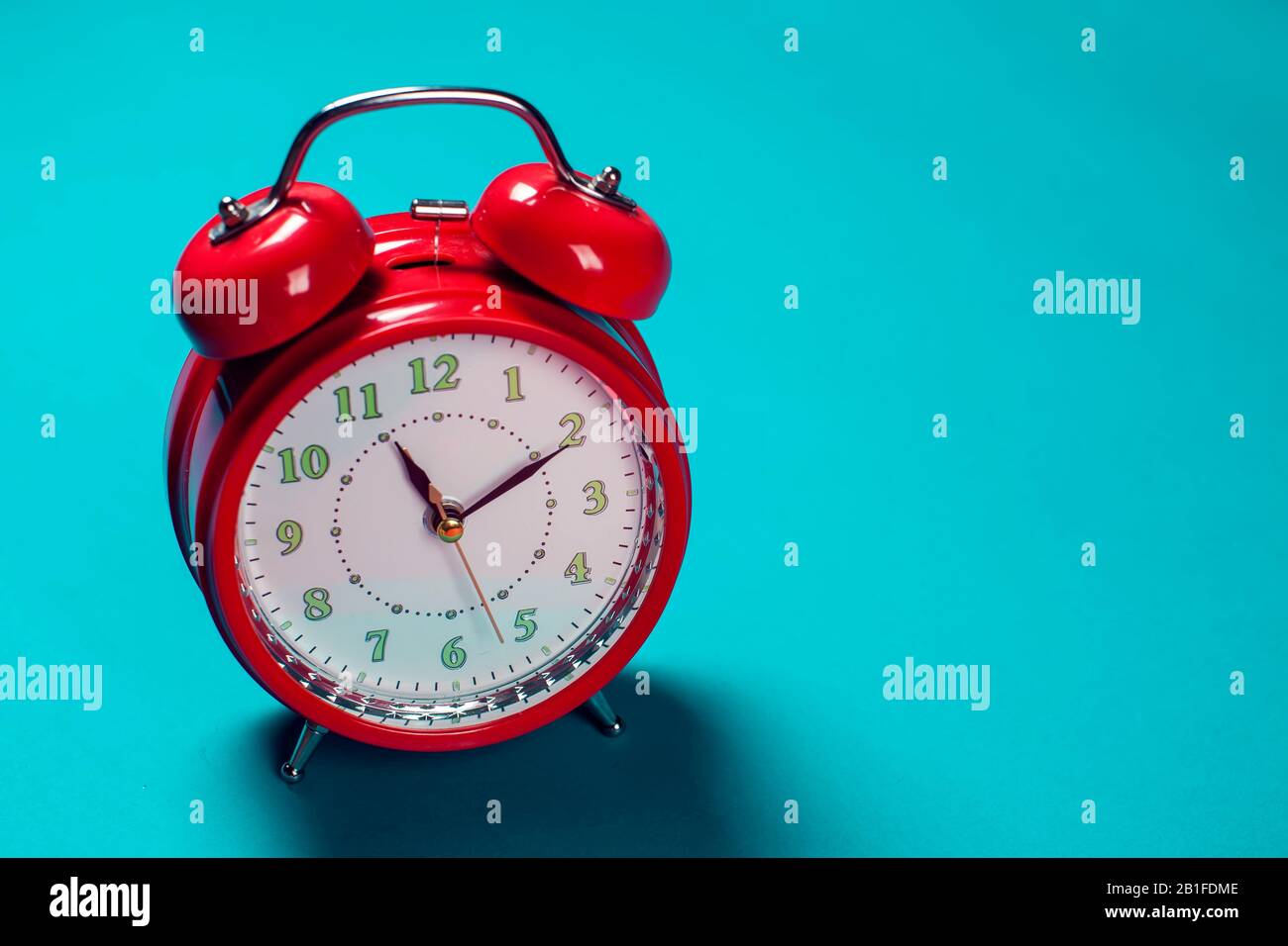 Red alarm clock on the color background. Stock Photo