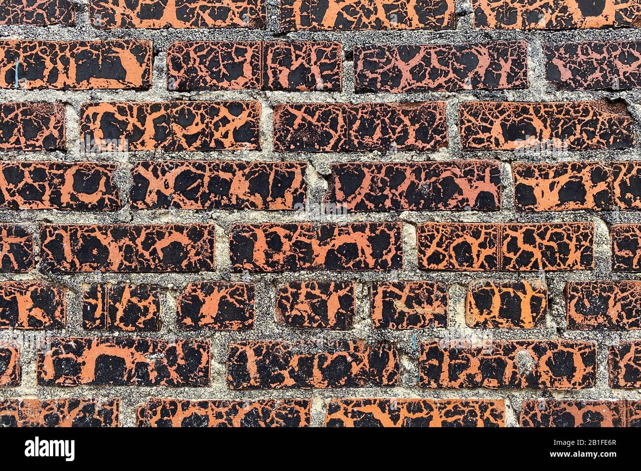 a beautiful peeling weathered aged vintage painted red brick wall close-up Stock Photo