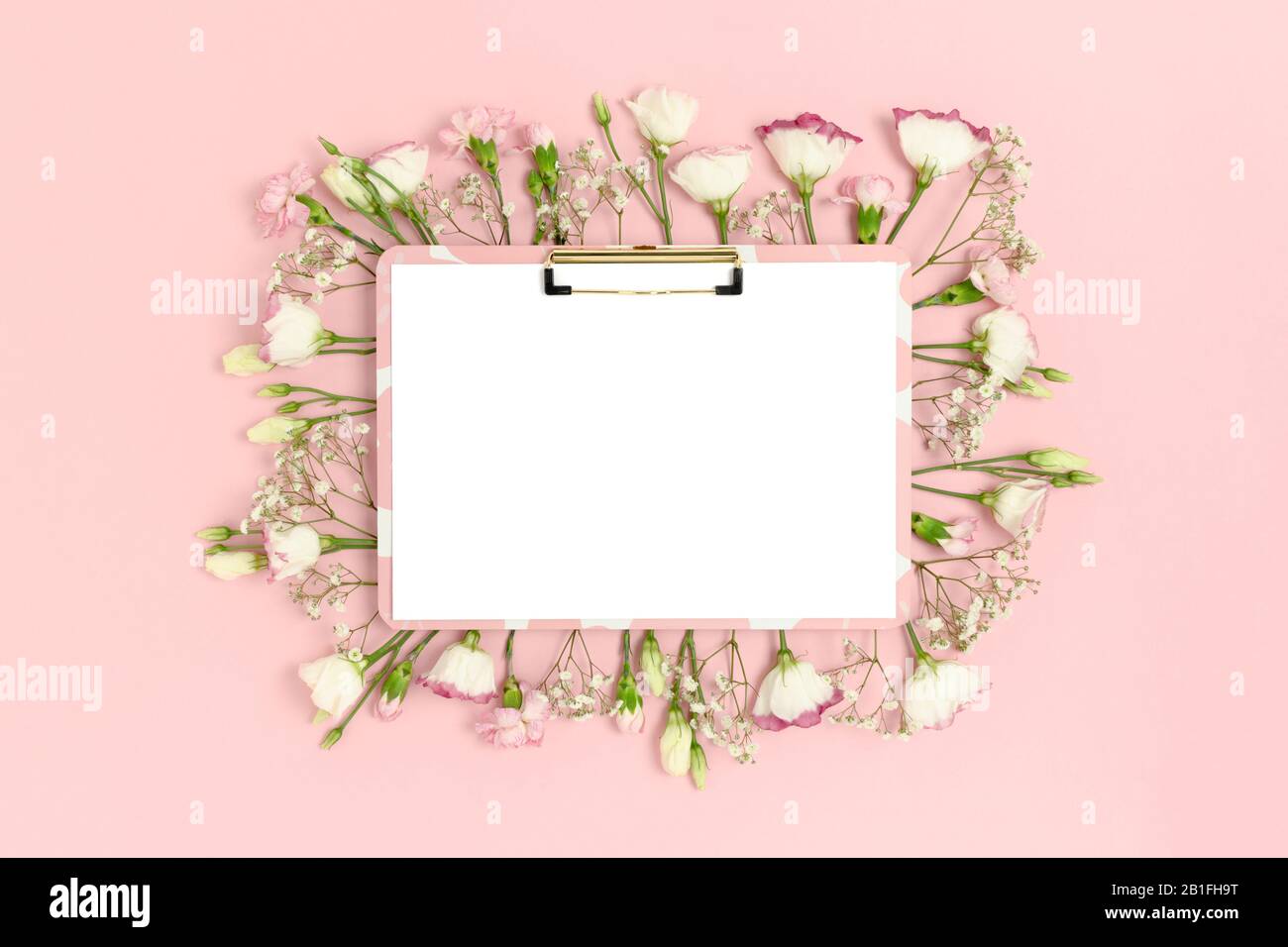 Clipboard mockup with blank paper card. Frame made of flowers on a pink ...
