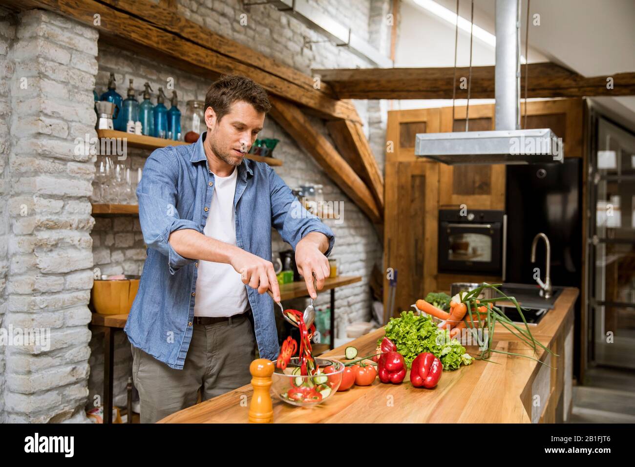 Young man preparing food in the rustic kitchen Stock Photo