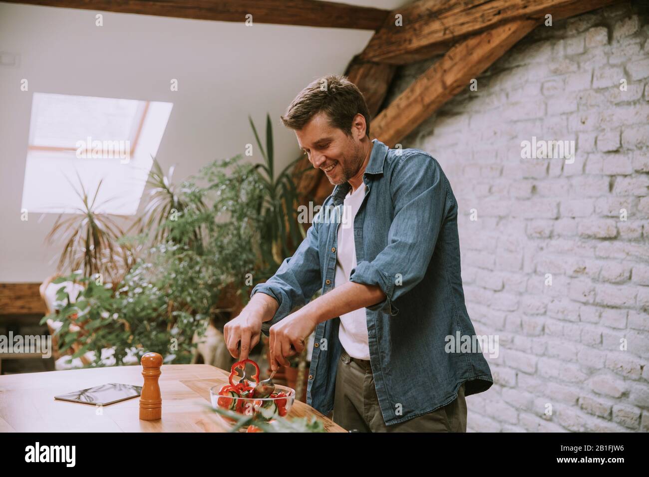 Young man preparing food in the rustic kitchen Stock Photo