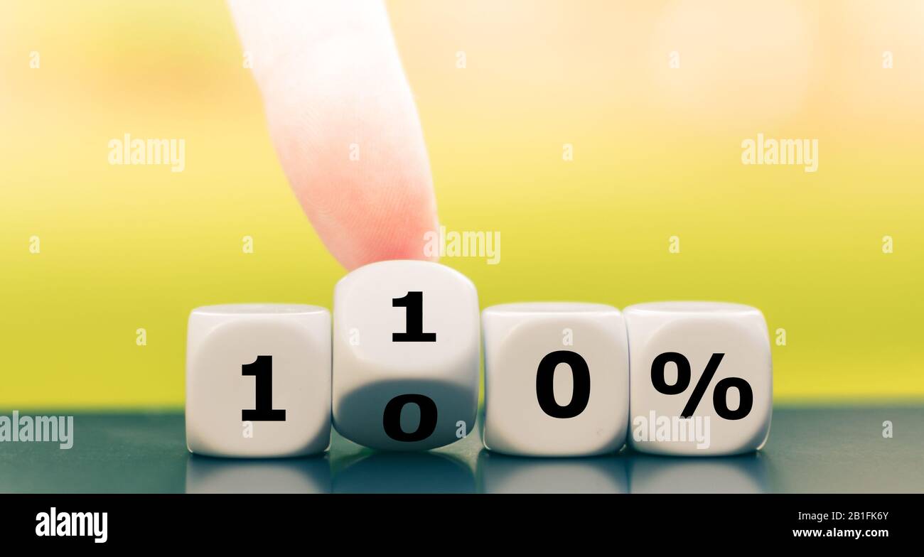 Hand turns dice and changes the expression '100%' to '110%'. Stock Photo