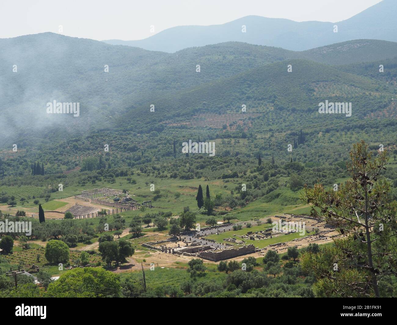 Looking down on the archaeological site of Ancient Messene, Ithomi, Messini, Messenia, Greece with the hills and mountains of the Peloponnese in the b Stock Photo