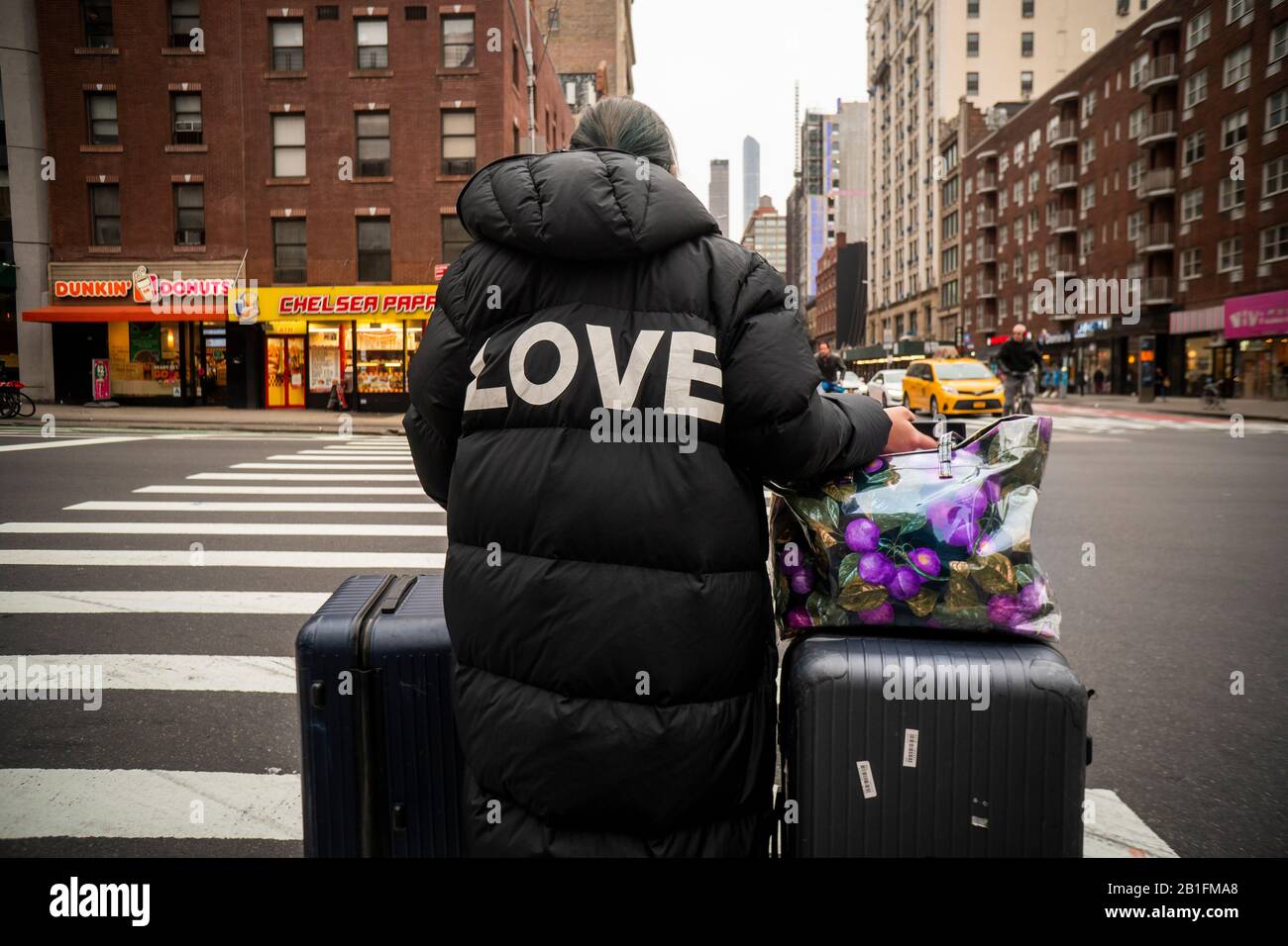 Traveler waits at an intersection the Chelsea neighborhood of New York on Tuesday, February 18, 2020. (© Richard B. Levine) Stock Photo