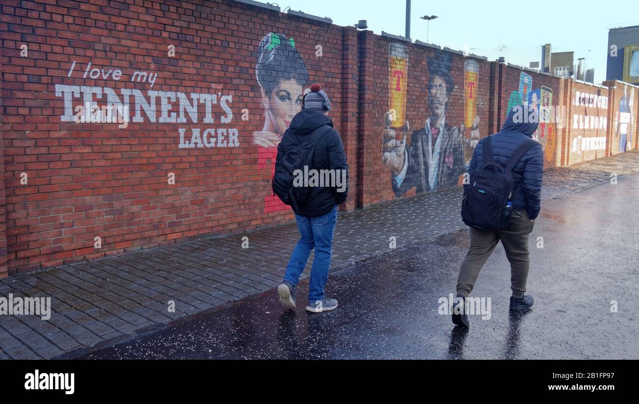 Tourists and locals brave wind and rain in  Denniston in the East end of the city near the Drygate tennents brewery. Stock Photo