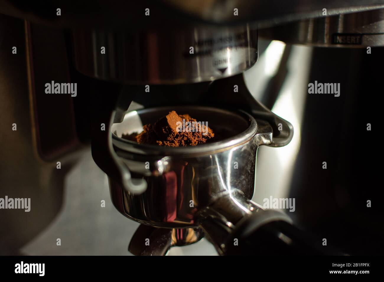 Espresso Machine grinding coffe beans into filter. machine ground coffe