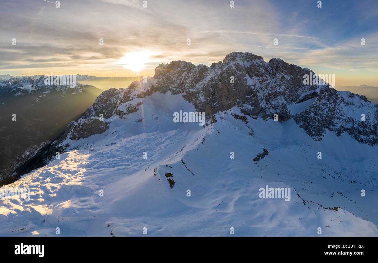 Aerial view of the north face of the Presolana mountain covered in snow in winter at sunrise. Stock Photo