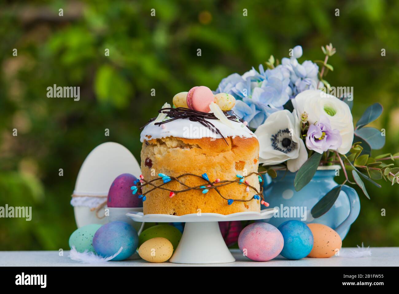 Easter sweet bread, flowers and colorful painted eggs Stock Photo