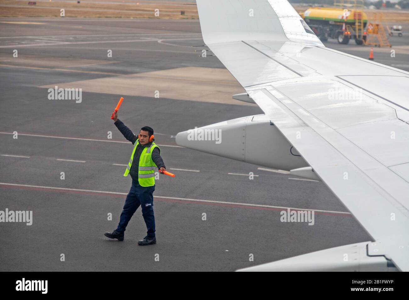Oaxaca, Mexico - A worker on the tarmac directs an American Airlines jet as it is backed away from the gate at Xoxocotlán International Airport. Stock Photo