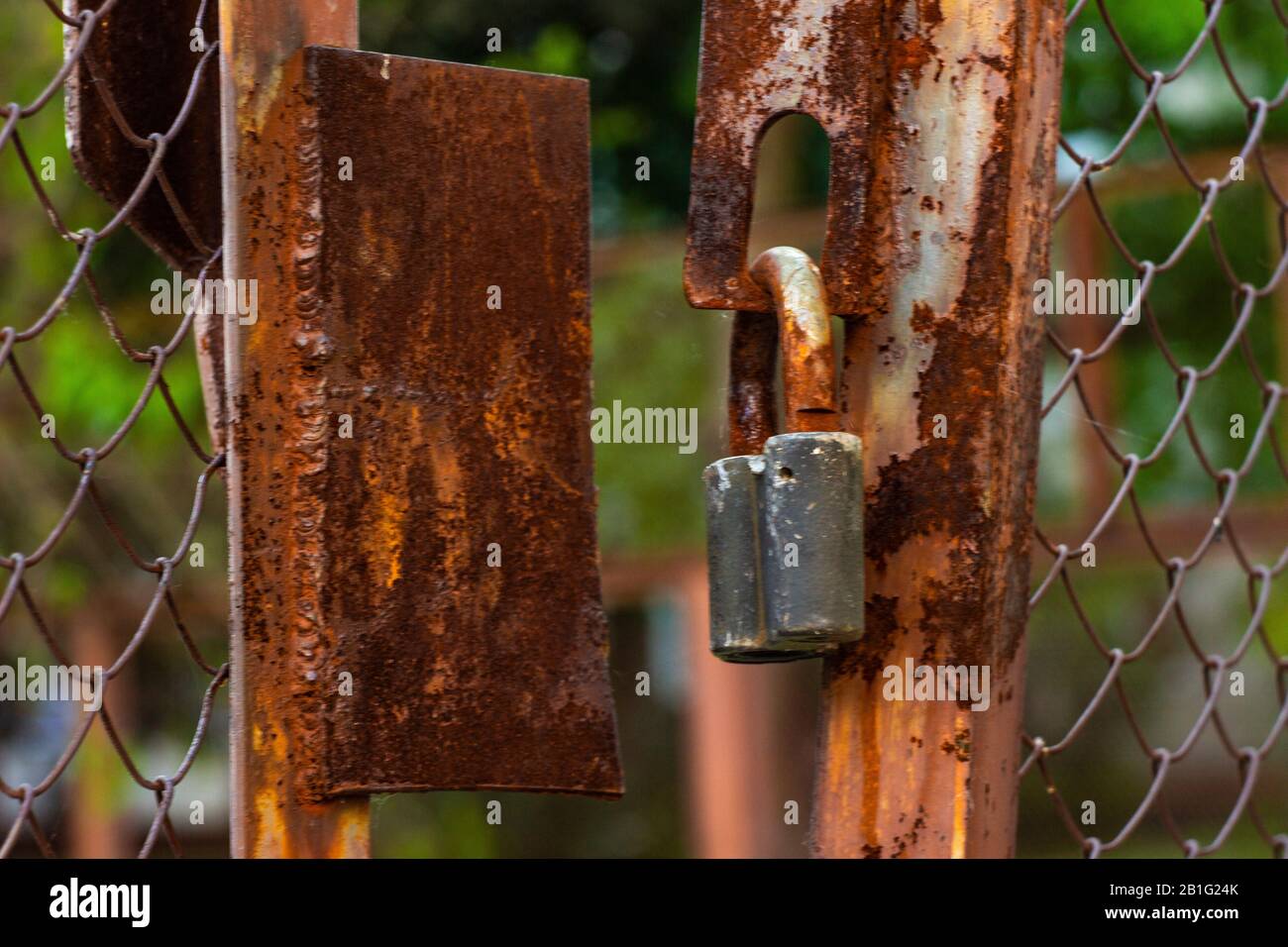 Rusty old lock. Locked padlock on metal grate. Concept - stolen things or unsecure data system Stock Photo