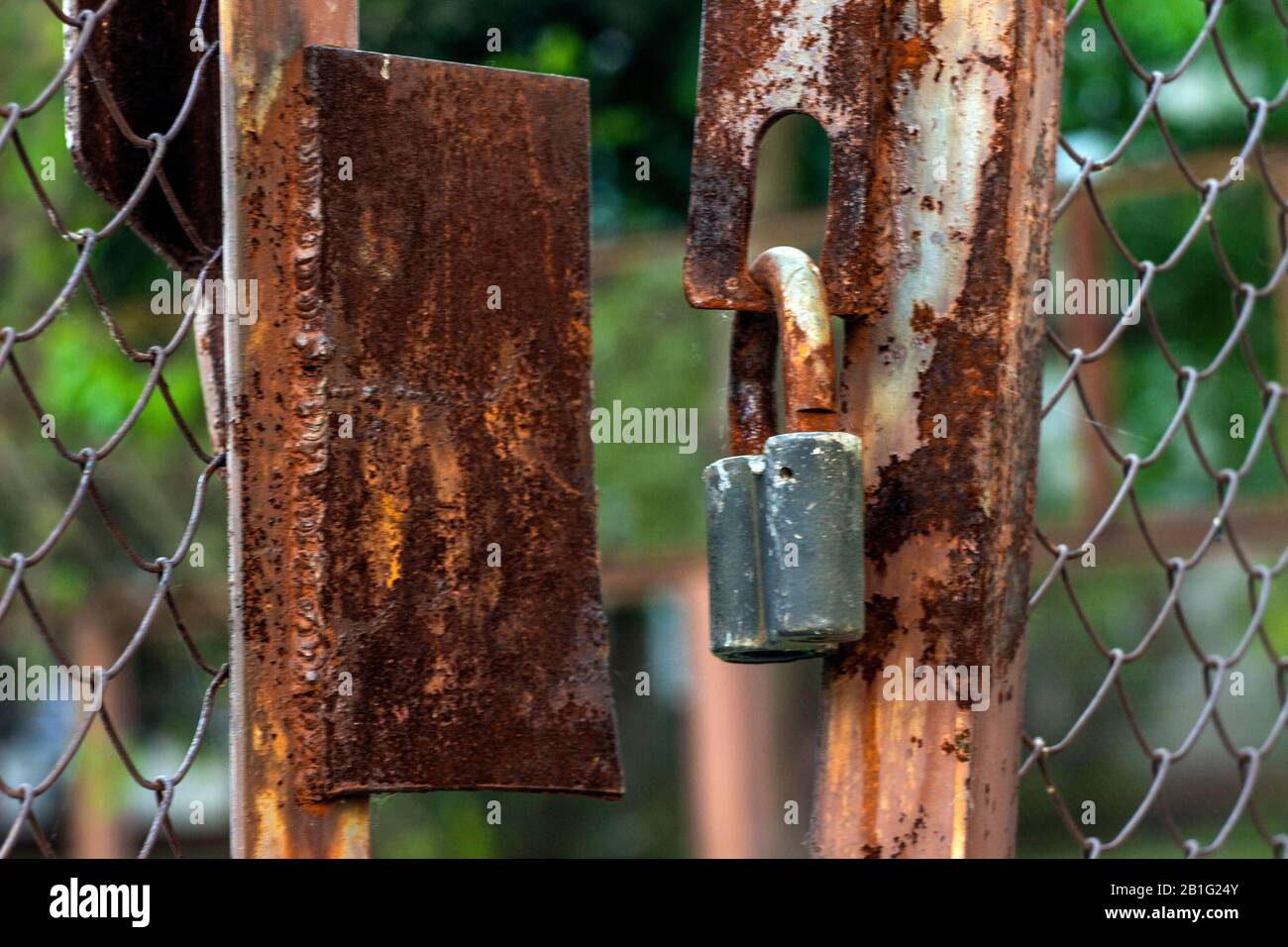 Rusty old lock. Locked padlock on metal grate. Concept - stolen things or unsecure data system Stock Photo