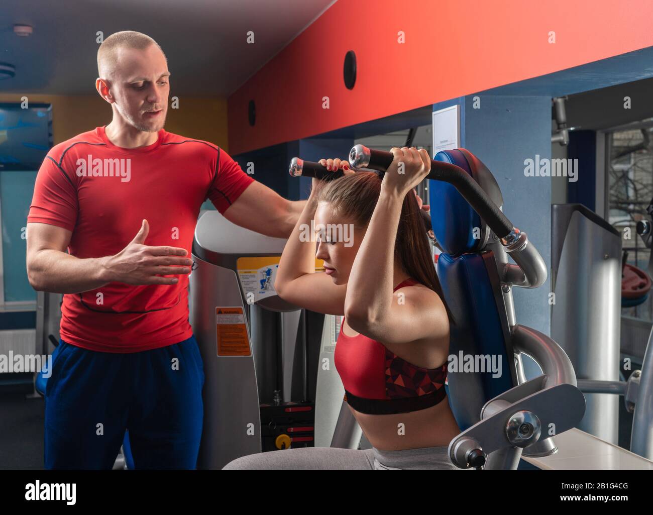 personal trainer man working with young woman in modern gym Stock Photo ...