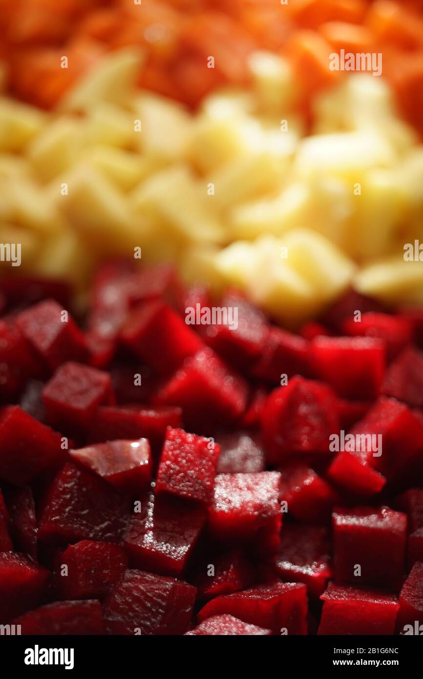 Square raw sliced beets, potatoes and carrots in three rows background. Side view closeup Stock Photo