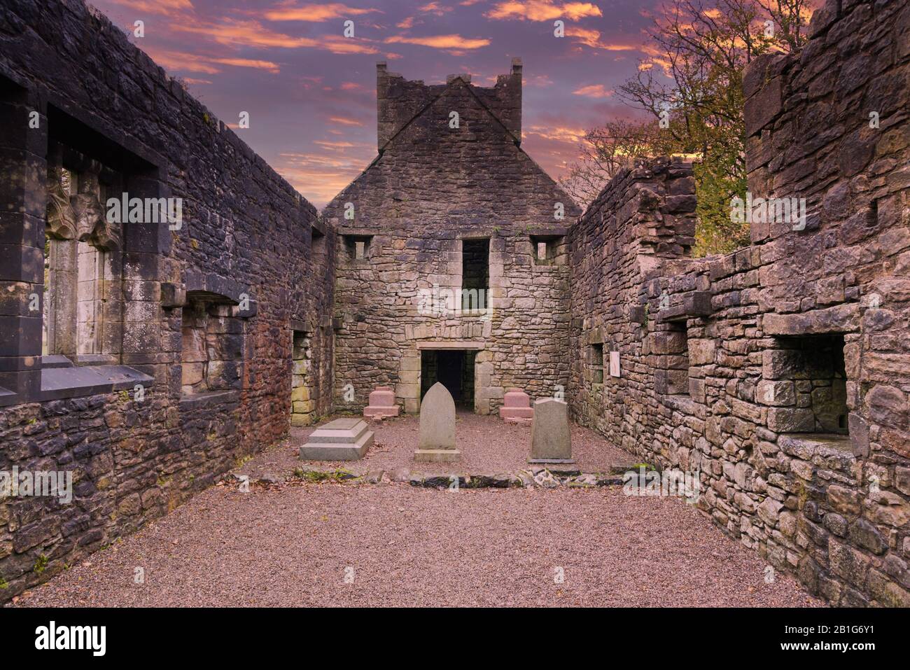 Looking to the internal walls and Gable of The Old Semple Ruins at Castle Semple in Renfrewshire Scotland at a Blazing Red sunset Stock Photo