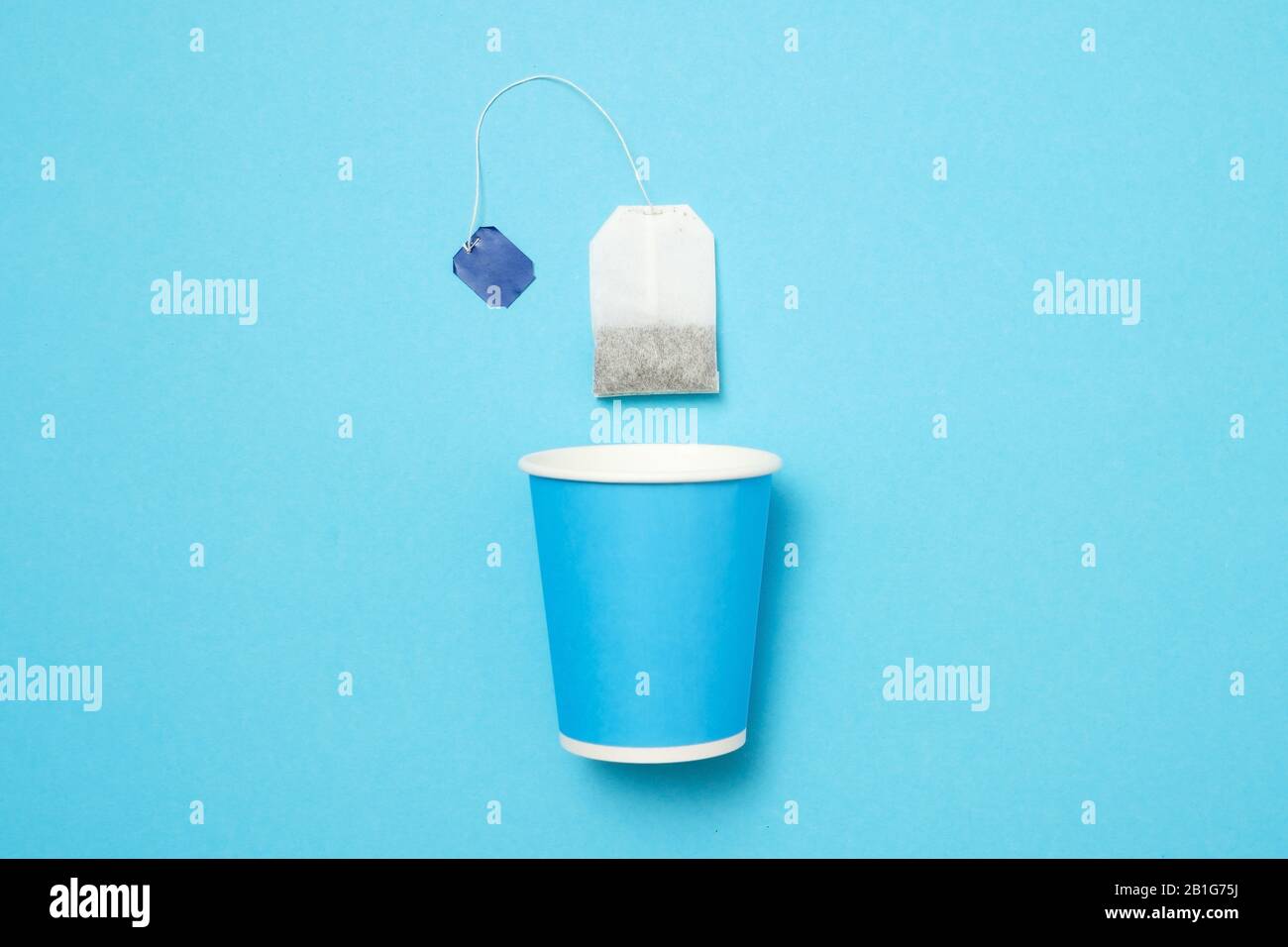 Blue paper cup with tea bag on blue wall. Top view Stock Photo - Alamy