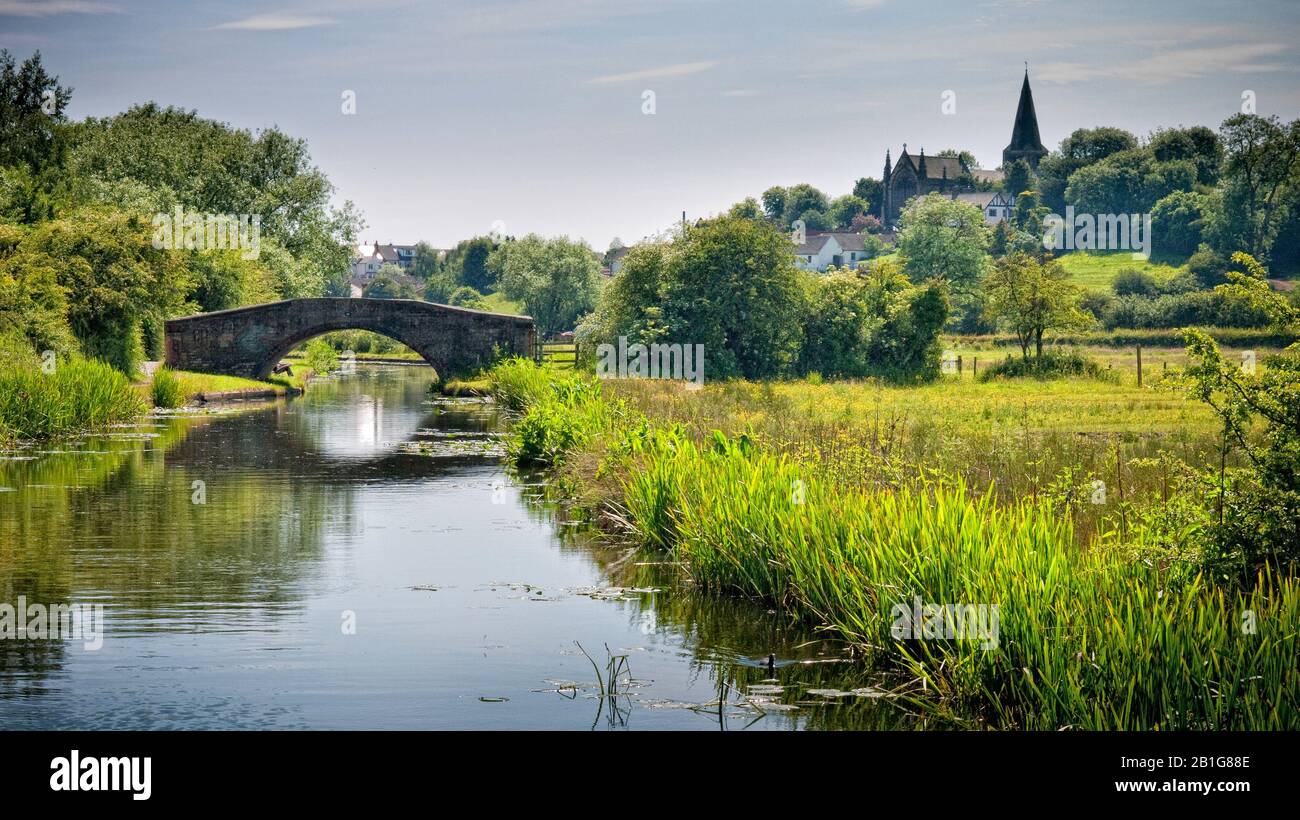 The Erewash Canal and arched bridge near Ilkeston with the Church and