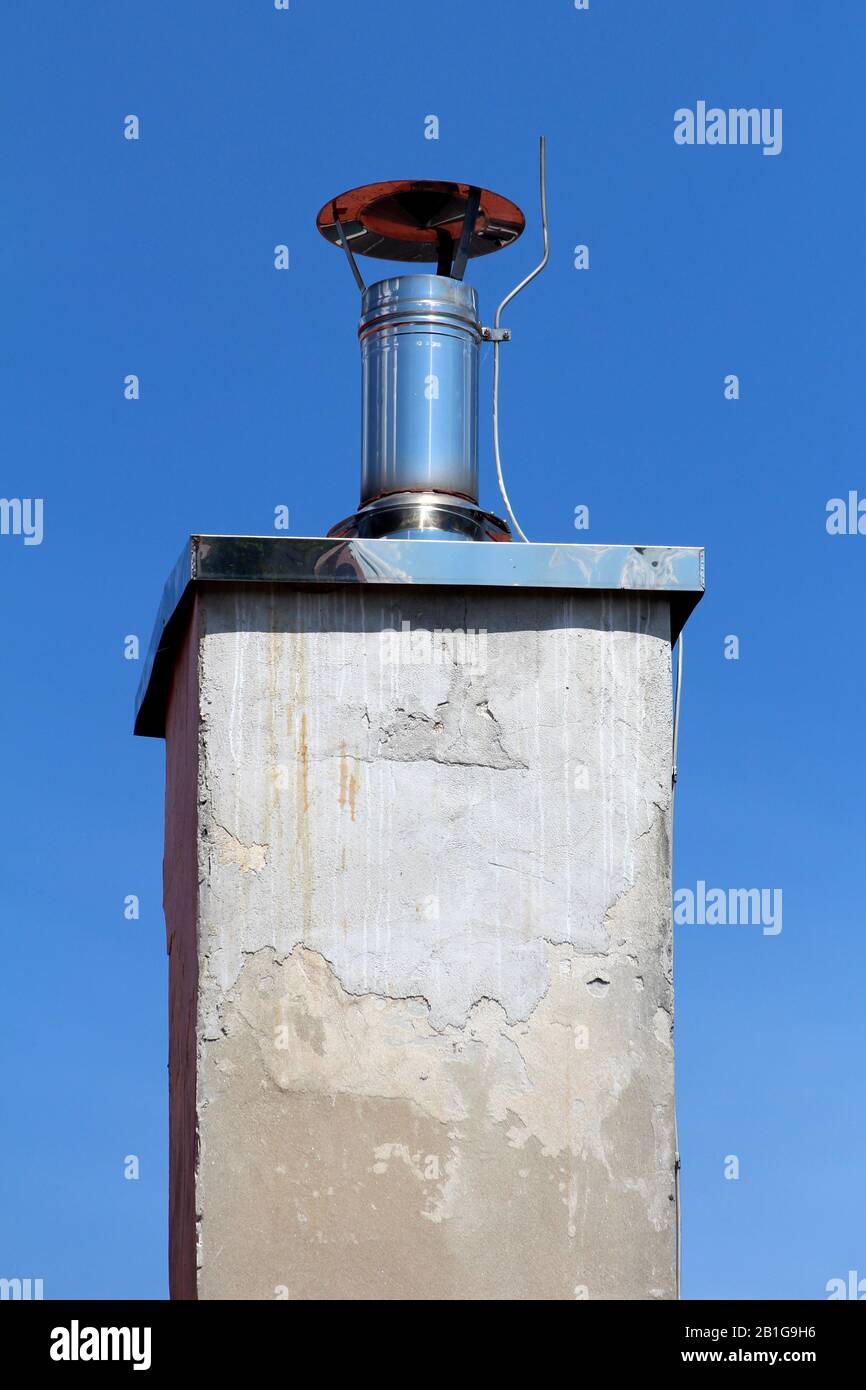 Shiny metal new small chimney with metal cap and lightning rod on top
