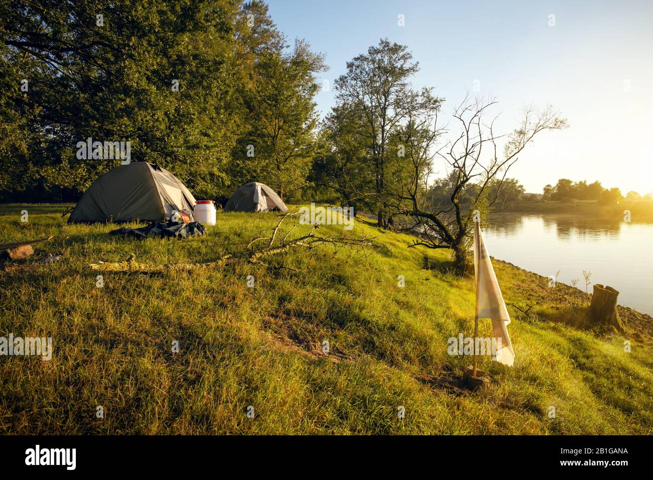 Two tents next to a river at sunrise Stock Photo - Alamy