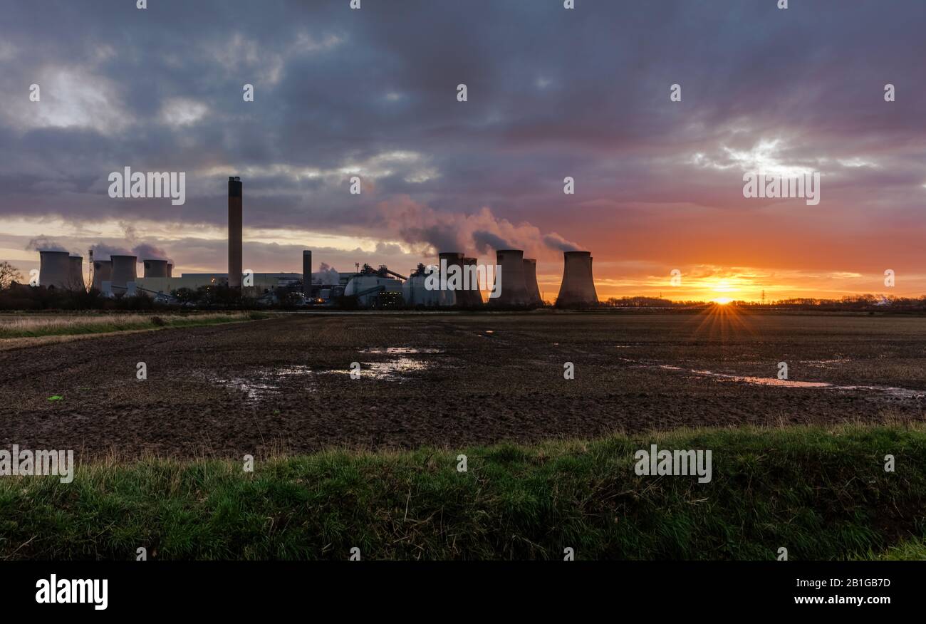 Early morning near Drax in North Yorkshire with the sun just about to rise in the East. Plumes of water vapour rising from the cooling towers of a loc Stock Photo