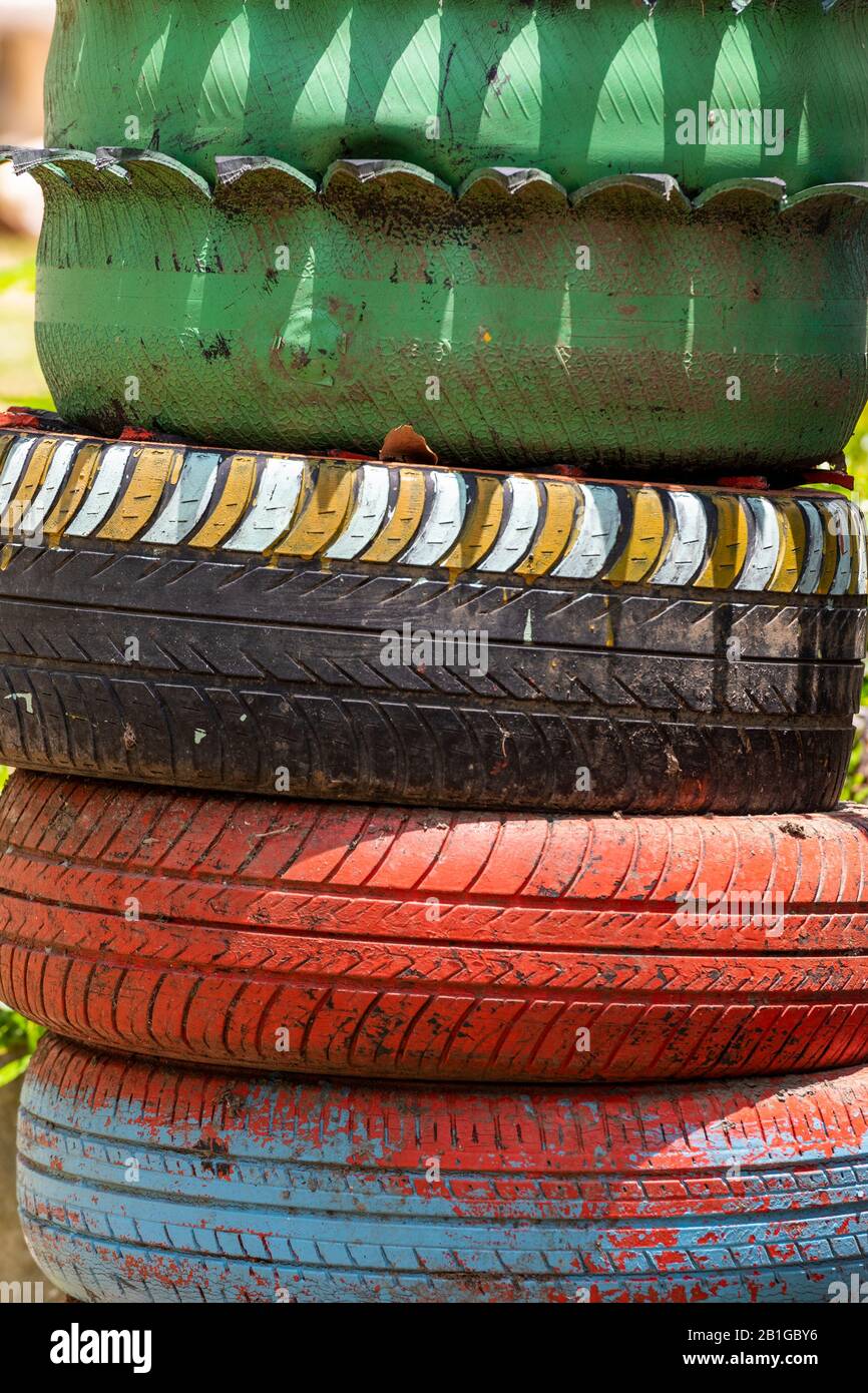 A pile of old car tyres made of rubber and painted in bright colours