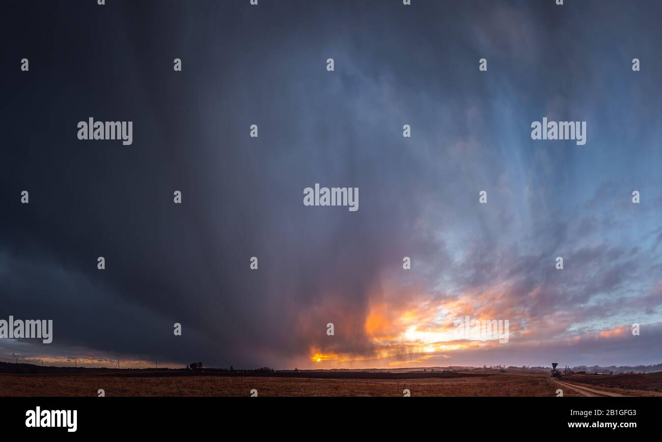 Rain falling from the sky in the evening light Stock Photo - Alamy