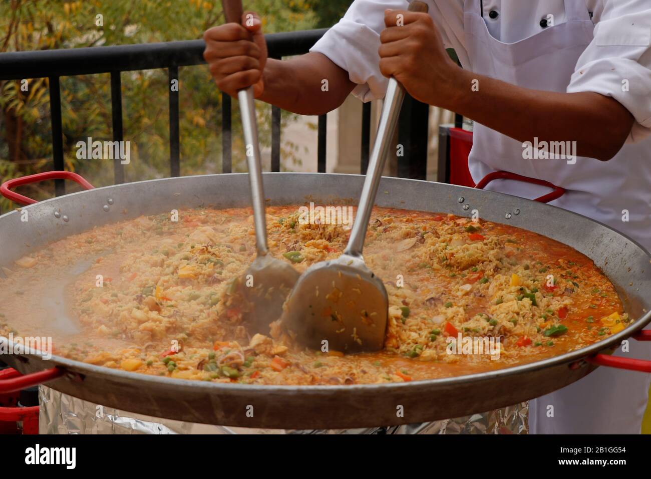 https://c8.alamy.com/comp/2B1GG54/chef-cooking-spanish-paella-in-outdoor-area-2B1GG54.jpg