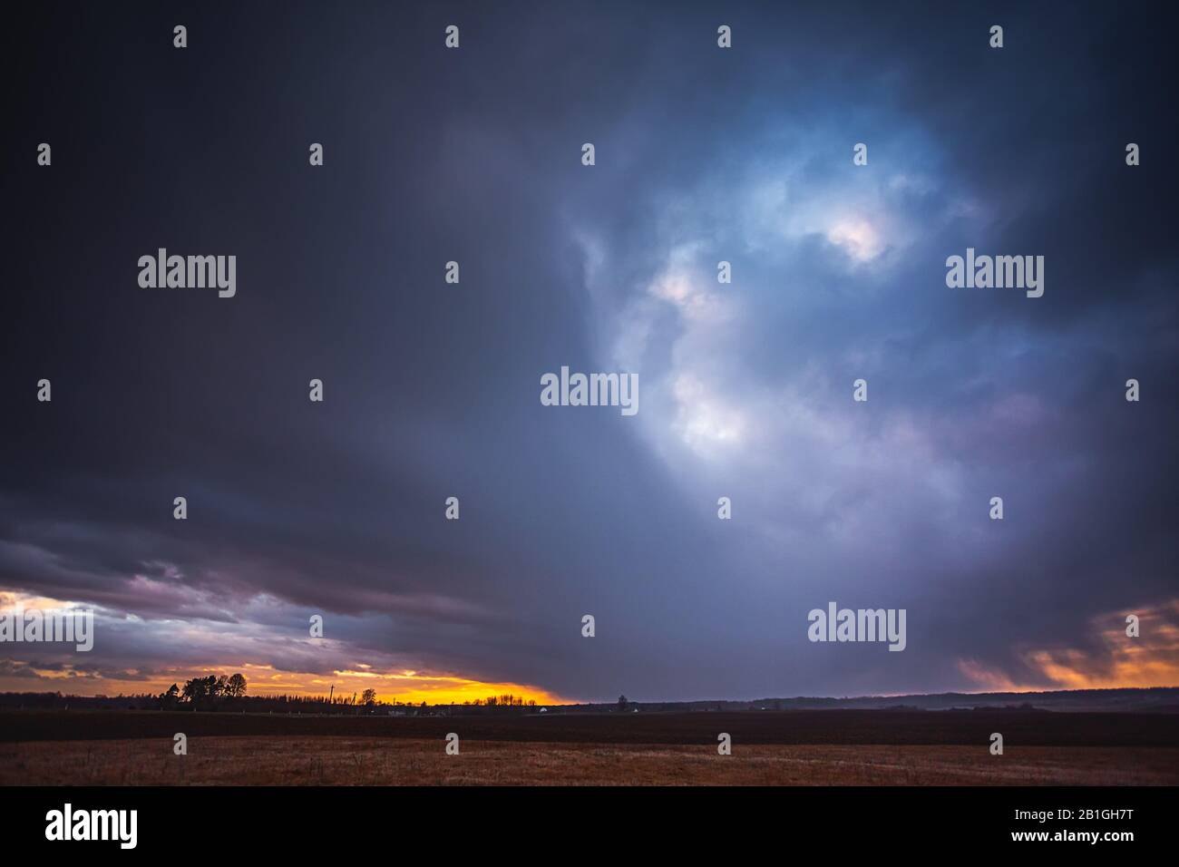 Rain falling from the sky in the evening light Stock Photo - Alamy