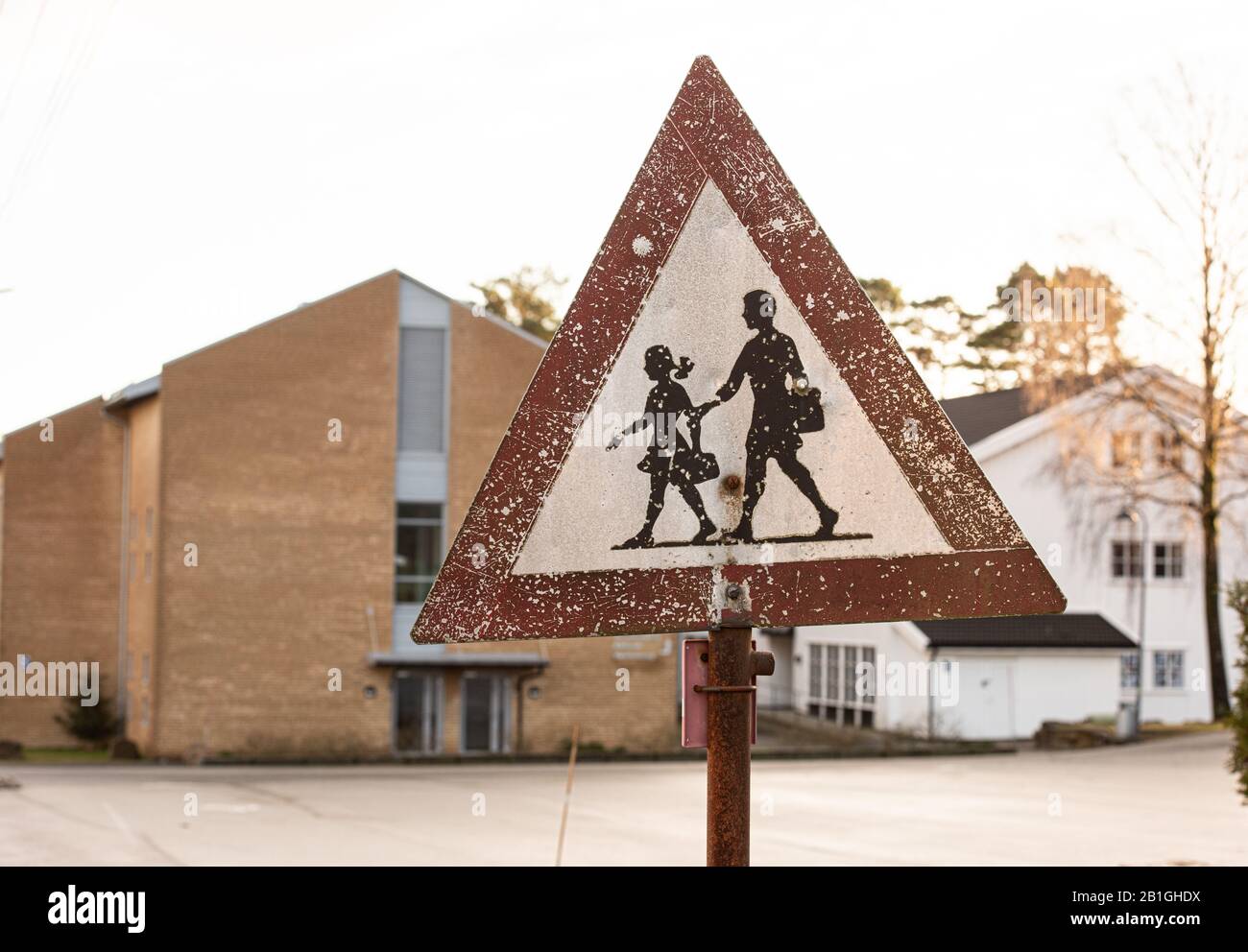 Worn school warning sign with scratches and a bullet hole. Stock Photo