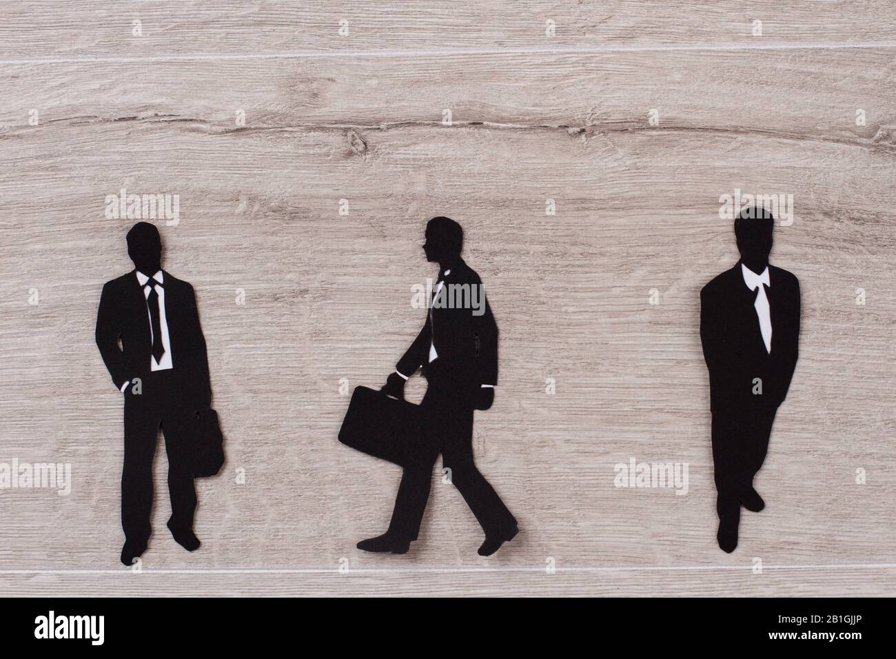 Three men in suits on wooden background. Stock Photo