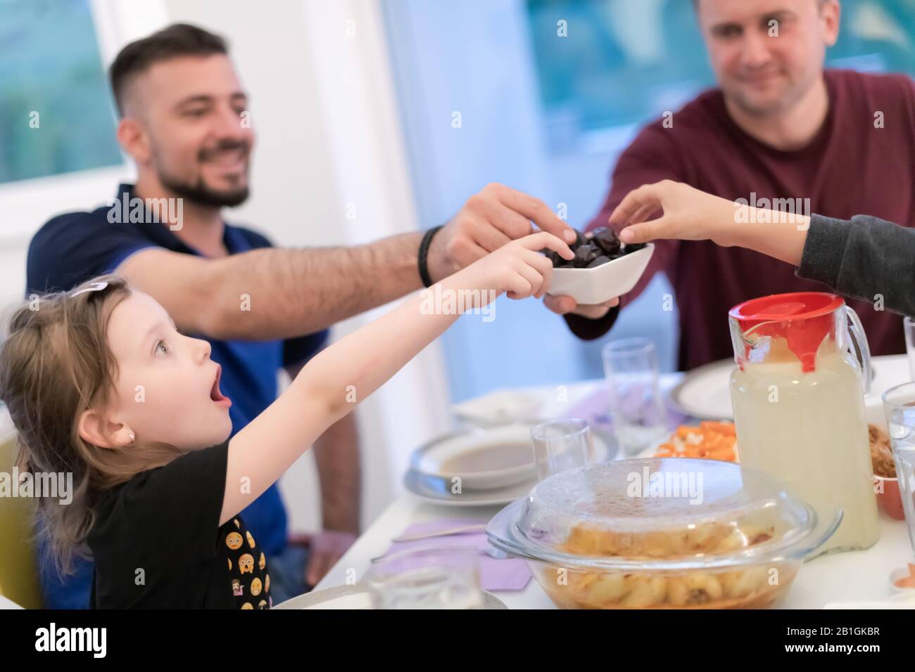 Eid Mubarak Muslim family having Iftar dinner eating dates to break