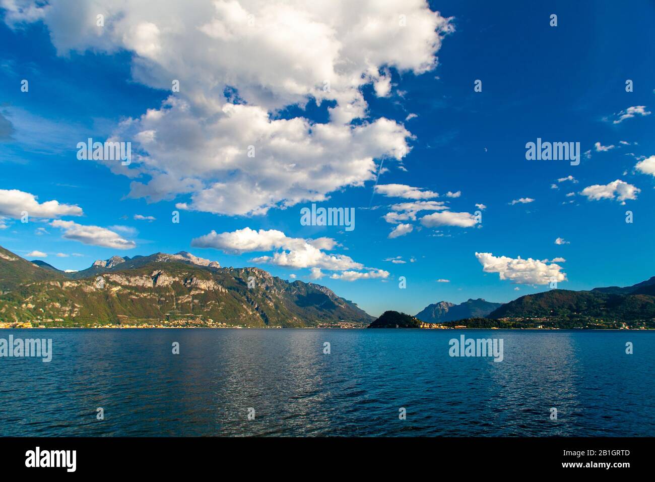 Lake Como landscape with mountains, blue sky and white clouds, Lombardy, italy Stock Photo