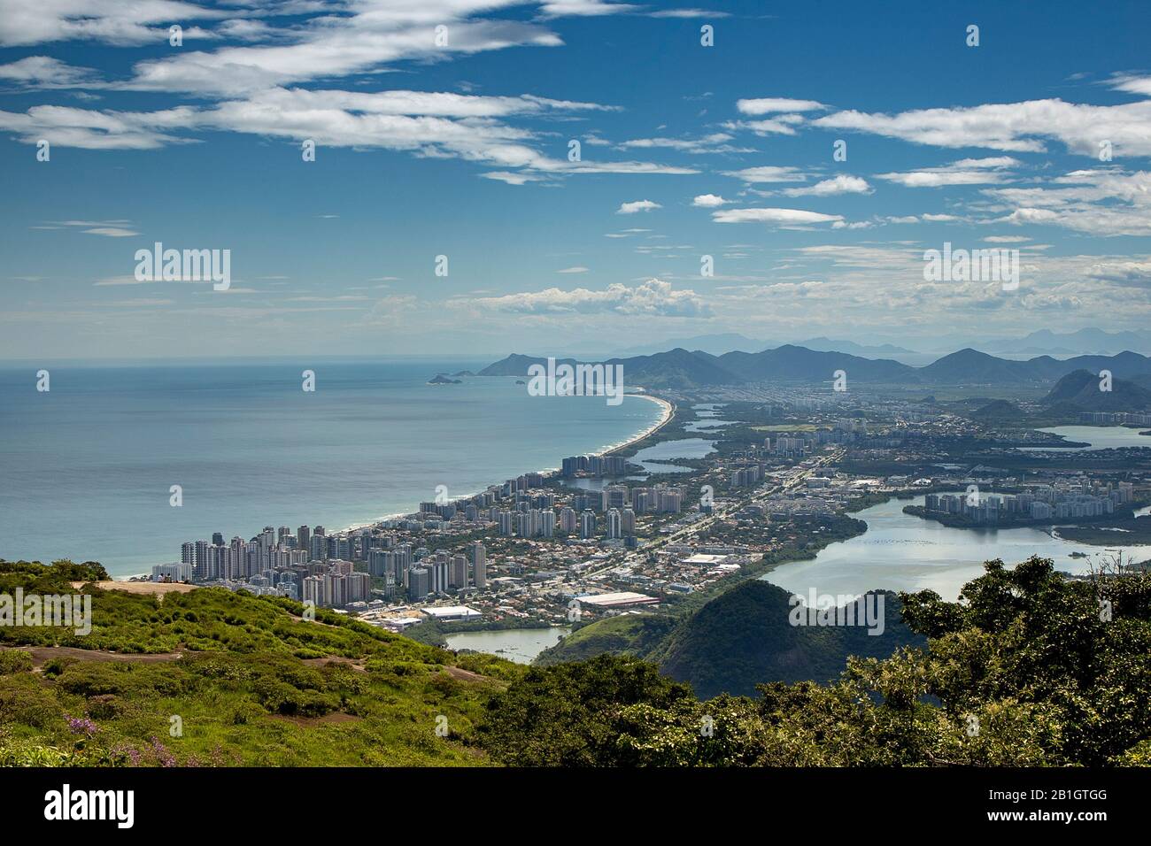 Hazy blue sky over Barra da Tijuca neighbourhood in Rio de Janeiro with vegetation from the Pedra Bonita lookout mountain Stock Photo