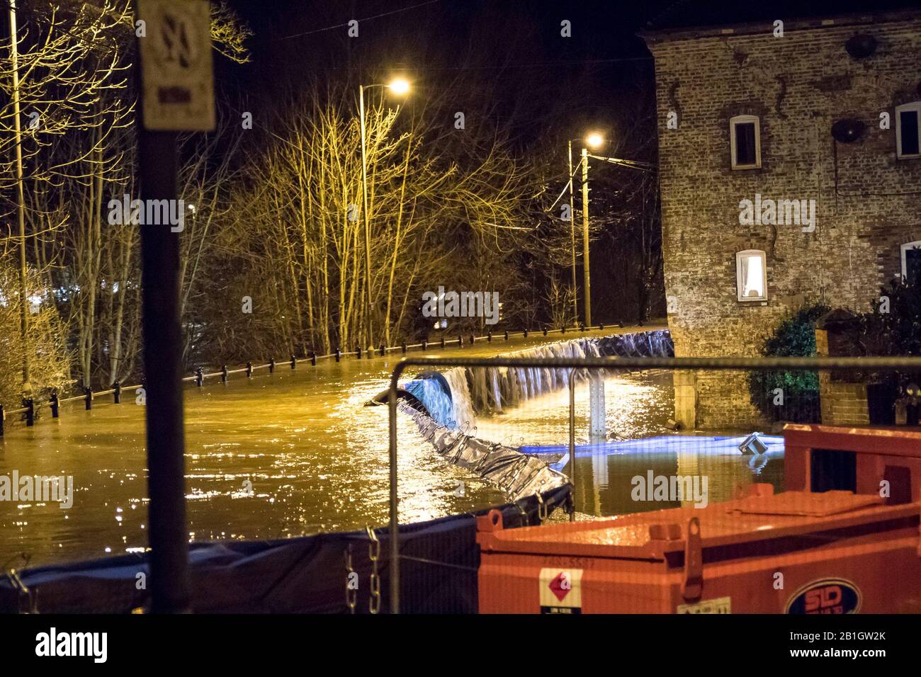 Bewdley, UK. 25th February, 2020. River levels reach an unprecedented high this evening at 9:30pm as flood water begins to dangerously pour over the top of the flood defence barriers at Beale's Corner in the Worcestershire town of Bewdley. Emergency services are in attendance working through the night ensuring industrial water pumps are in constant use pumping as much water as possible back into the River Severn and away from the perilously close surrounding propertiesn at risk. Credit: Lee Hudson/Alamy Live News Stock Photo
