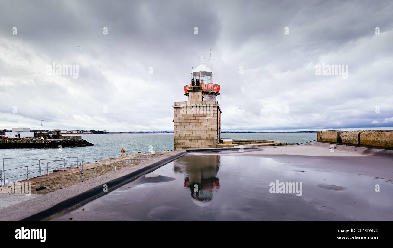 Howth Lighthouse reflected in water. Cloudy weather Howth harbour