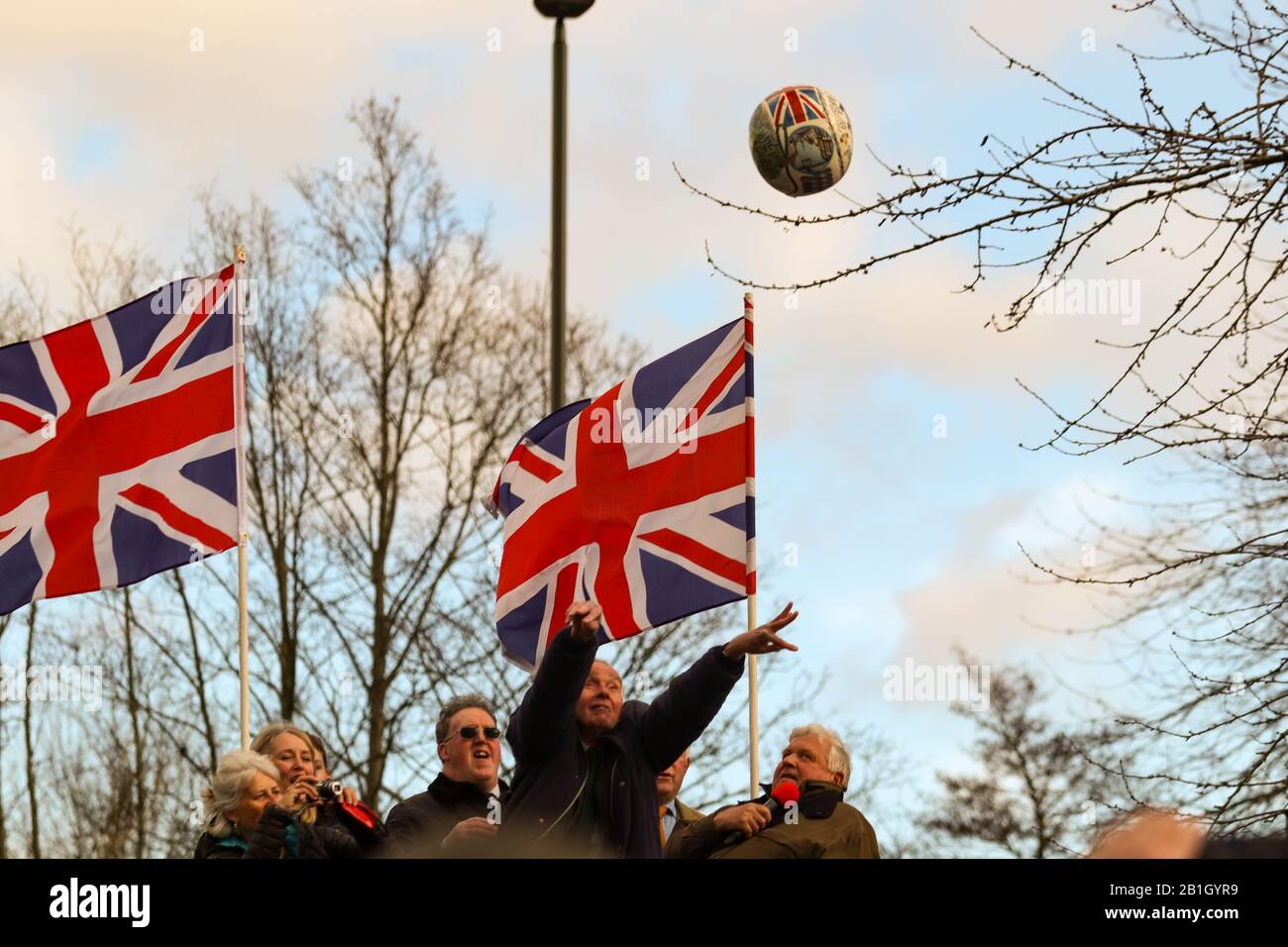 Ashbourne, UK. 25th Feb, 2020. Andrew Lemon 'turns up' the ball from the plinth at Shaw Croft car park. The first day of the two day Shrovetide Football Game in the market town of Ashbourne, Derbyshire. The game is played with two teams, the Up'Ards and the Down'Ards. There are two goal posts 3 miles (4.8 km) apart, one at Sturston Mill (where the Up'Ards attempt to score), other at Clifton Mill (where the Down'Ards score). Penelope Barritt/Alamy Live News Stock Photo