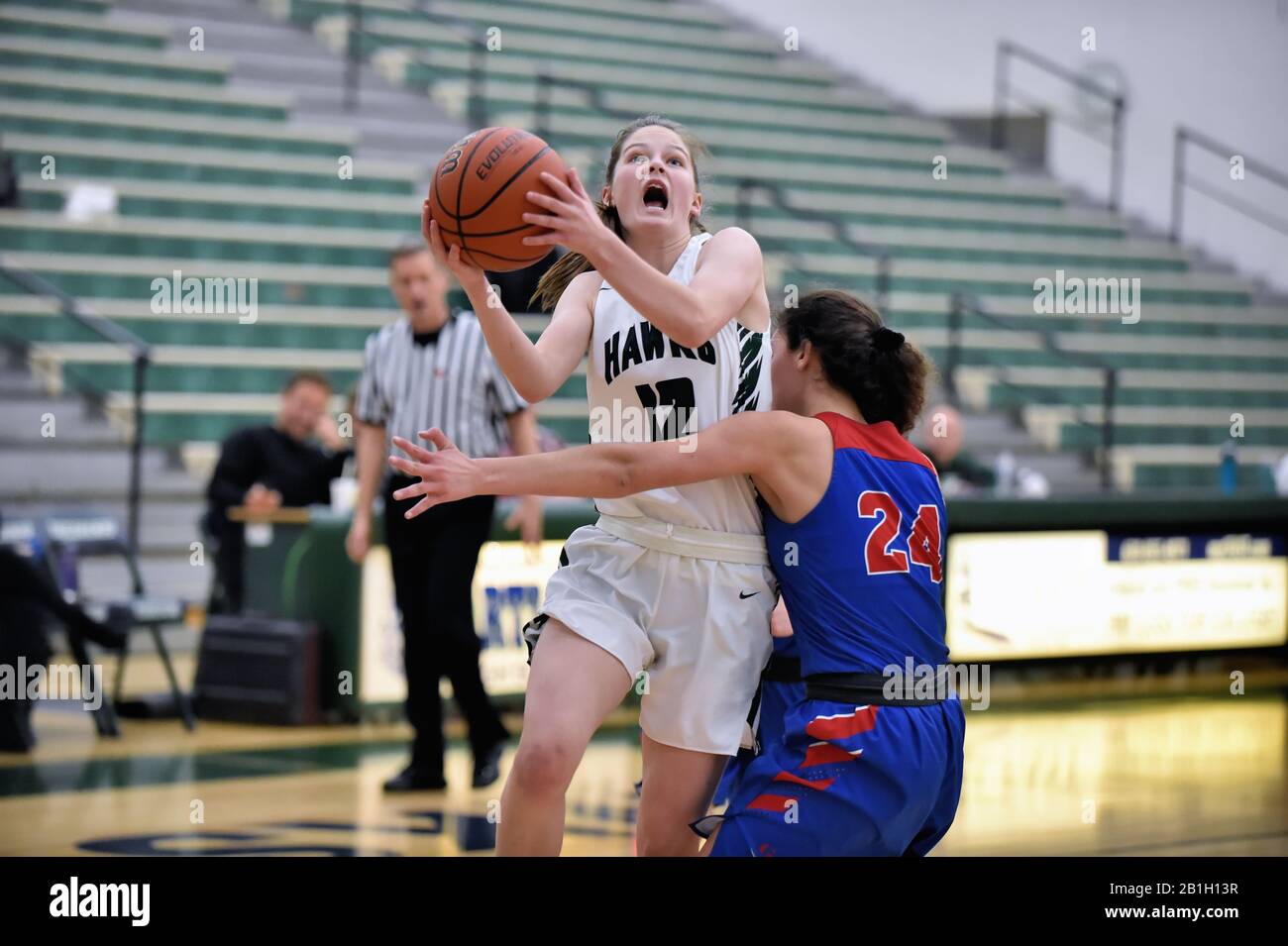 Player finishing off a drive on the basket while shooting over a defending opponent. USA. Stock Photo