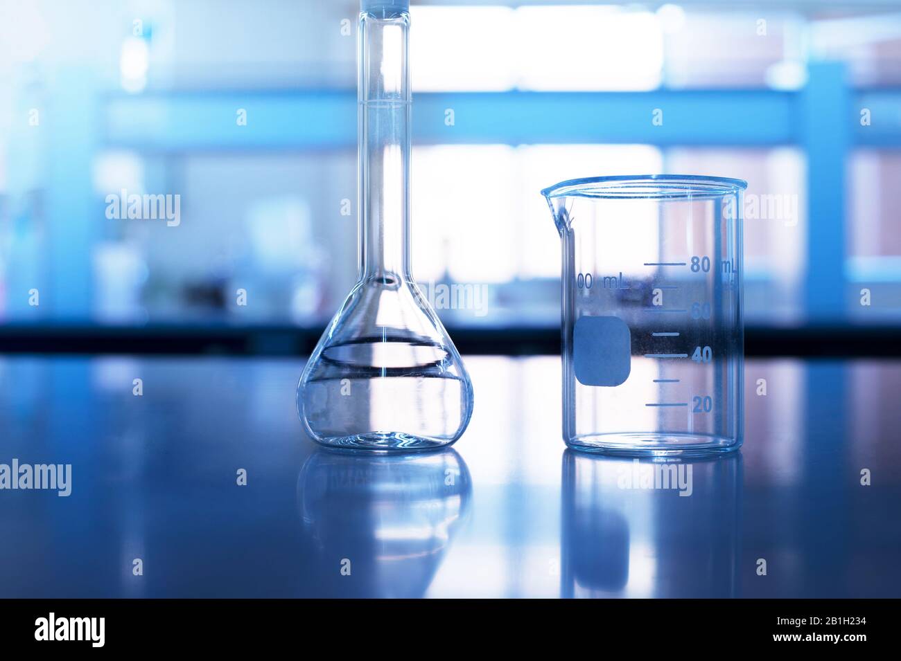 beaker and volumetric flask on chemistry science blue laboratory table